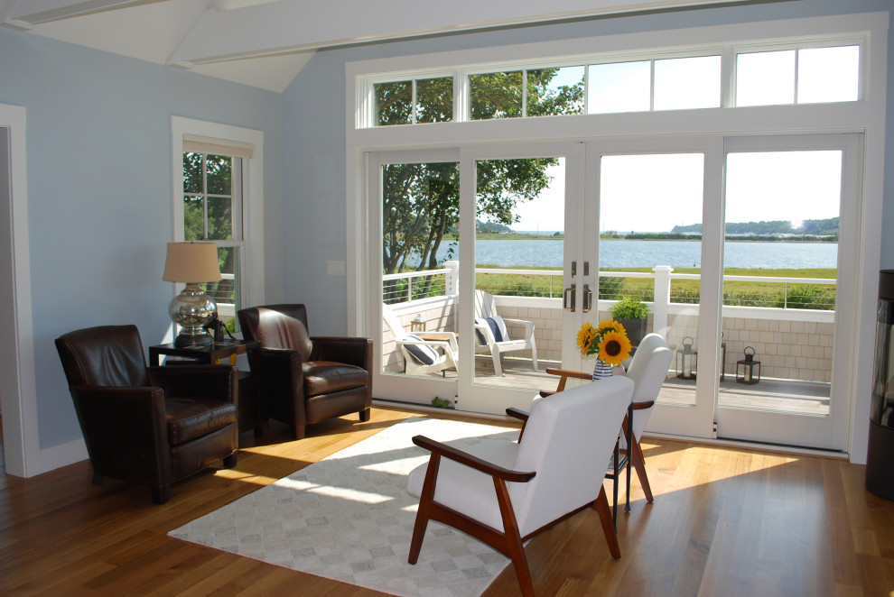 Пример оригинального дизайна: открытая гостиная комната среднего размера в морском стиле с синими стенами, светлым паркетным полом, угловым камином, фасадом камина из металла и балками на потолке