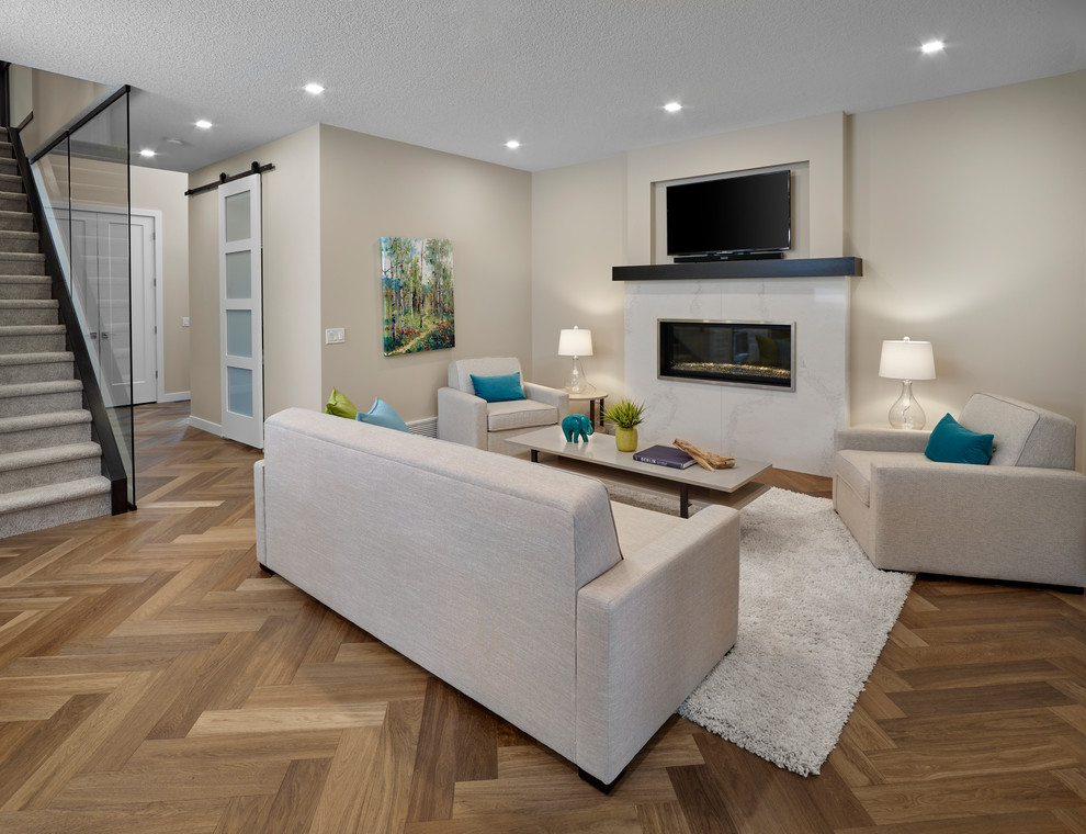 Mittelgroßer, Offener Moderner Hobbyraum mit beiger Wandfarbe, braunem Holzboden, Kamin, Kaminumrandung aus Stein, TV-Wand und braunem Boden in Edmonton