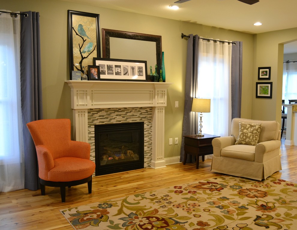 Exemple d'une salle de séjour chic avec un mur vert, parquet clair, une cheminée standard et un manteau de cheminée en carrelage.