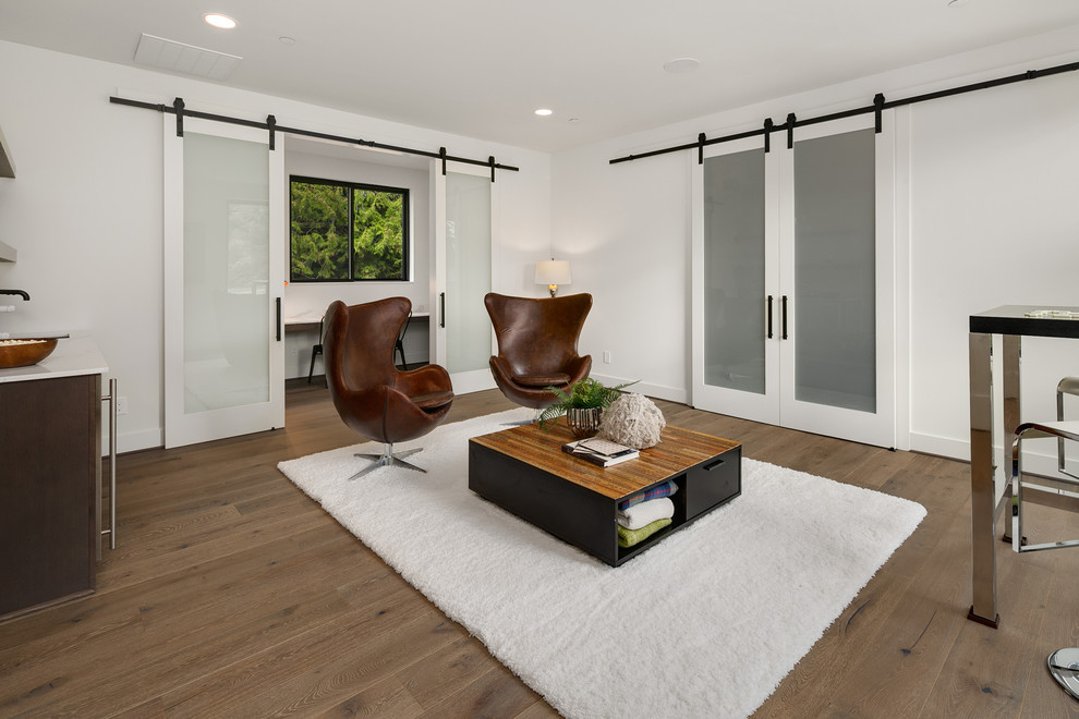 Immagine di un grande soggiorno design aperto con angolo bar, pareti bianche, pavimento in legno massello medio, nessuna TV e pavimento grigio