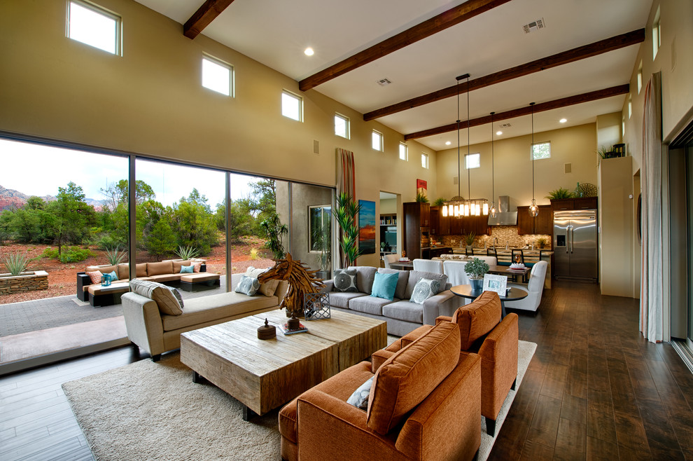 Modelo de sala de estar abierta clásica renovada con paredes beige y suelo de madera oscura