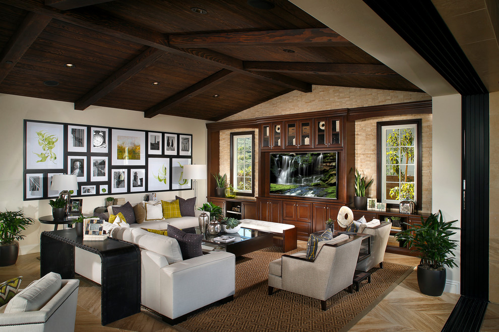 Design ideas for an expansive mediterranean open plan games room in San Diego with beige walls, a built-in media unit and light hardwood flooring.