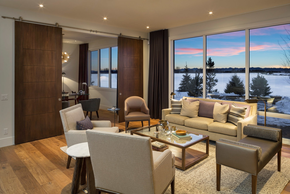 Repräsentatives Modernes Wohnzimmer mit beiger Wandfarbe und braunem Holzboden in Calgary