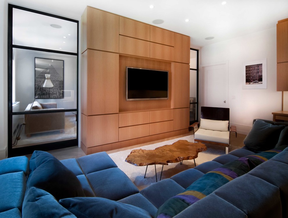 Свежая идея для дизайна: изолированная гостиная комната в современном стиле с белыми стенами, мультимедийным центром и синим диваном - отличное фото интерьера