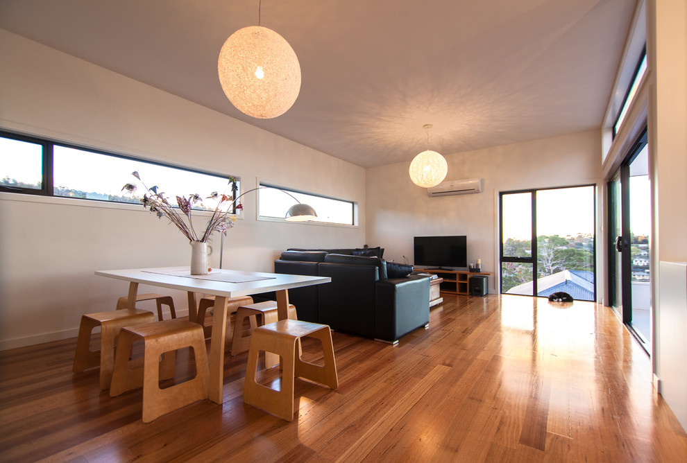 Small contemporary open plan games room in Hobart with white walls, light hardwood flooring and a freestanding tv.