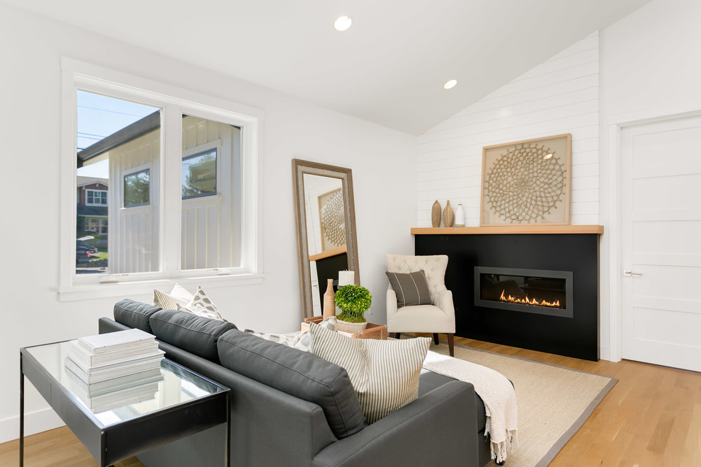 Inspiration for a medium sized contemporary open plan games room in Seattle with white walls, light hardwood flooring, a ribbon fireplace, a plastered fireplace surround, no tv and beige floors.
