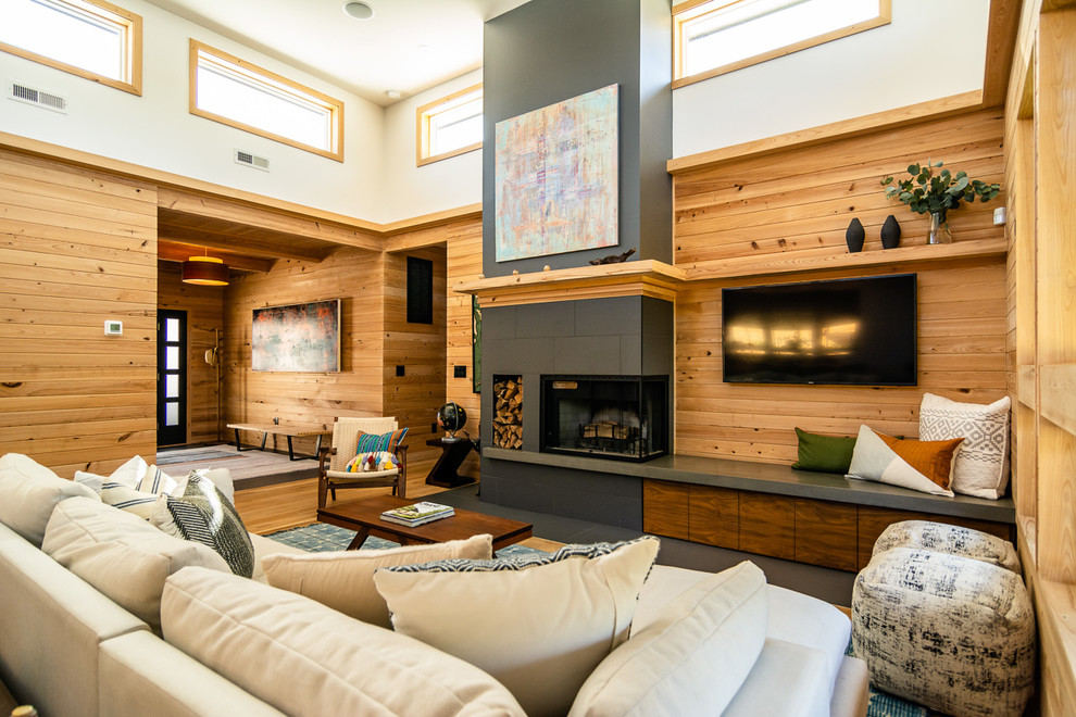 Modelo de sala de estar rural con paredes blancas, suelo de madera en tonos medios, todas las chimeneas y televisor colgado en la pared