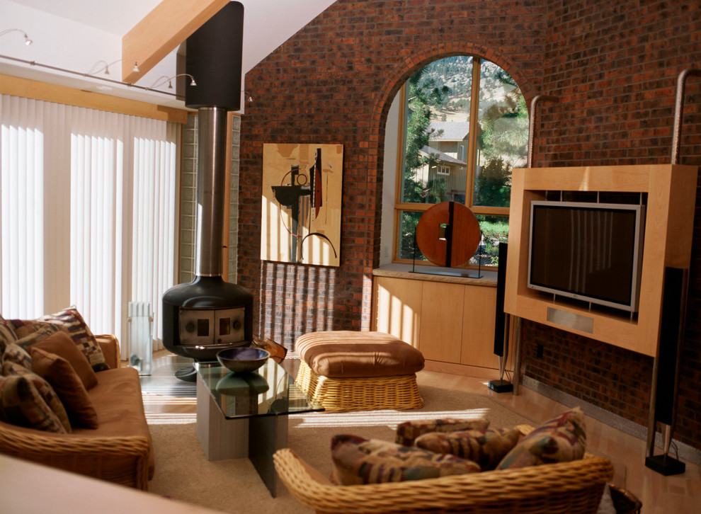Immagine di un soggiorno design di medie dimensioni e chiuso con pareti rosse, parquet chiaro, stufa a legna, cornice del camino in metallo, TV a parete e pavimento beige