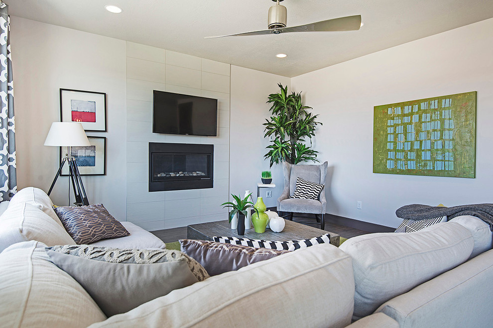 Cette image montre une salle de séjour design ouverte avec un mur blanc, parquet en bambou, une cheminée standard, un manteau de cheminée en carrelage et un téléviseur fixé au mur.