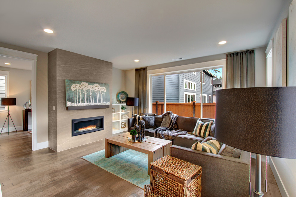 Diseño de sala de estar abierta clásica renovada sin televisor con paredes grises, suelo de madera en tonos medios y chimenea lineal