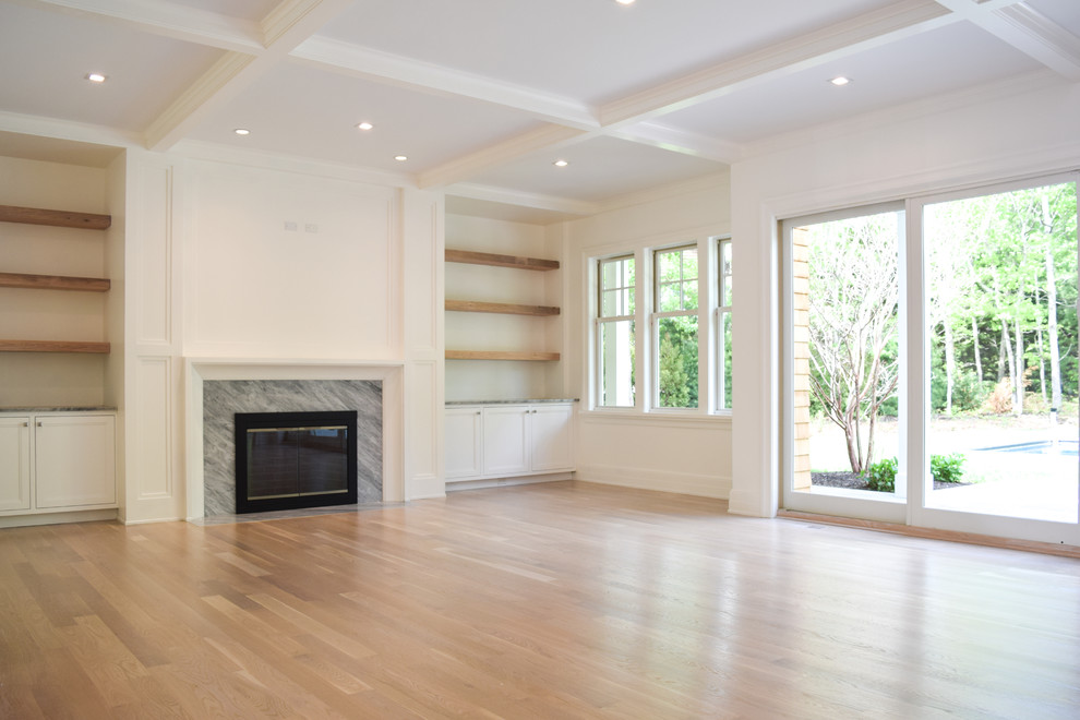 Inspiration for an expansive coastal open plan games room in New York with white walls, light hardwood flooring, a standard fireplace, a wooden fireplace surround and a wall mounted tv.