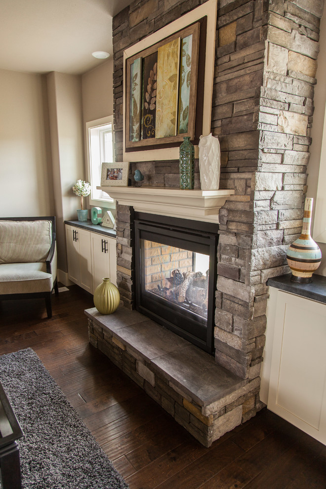Inspiration for a craftsman family room remodel in Minneapolis with a two-sided fireplace and a stone fireplace