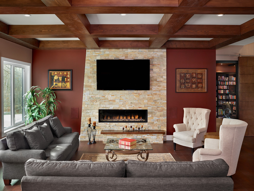 Ejemplo de sala de estar abierta clásica renovada grande con chimenea lineal, televisor colgado en la pared, paredes rojas, suelo de madera oscura y marco de chimenea de piedra