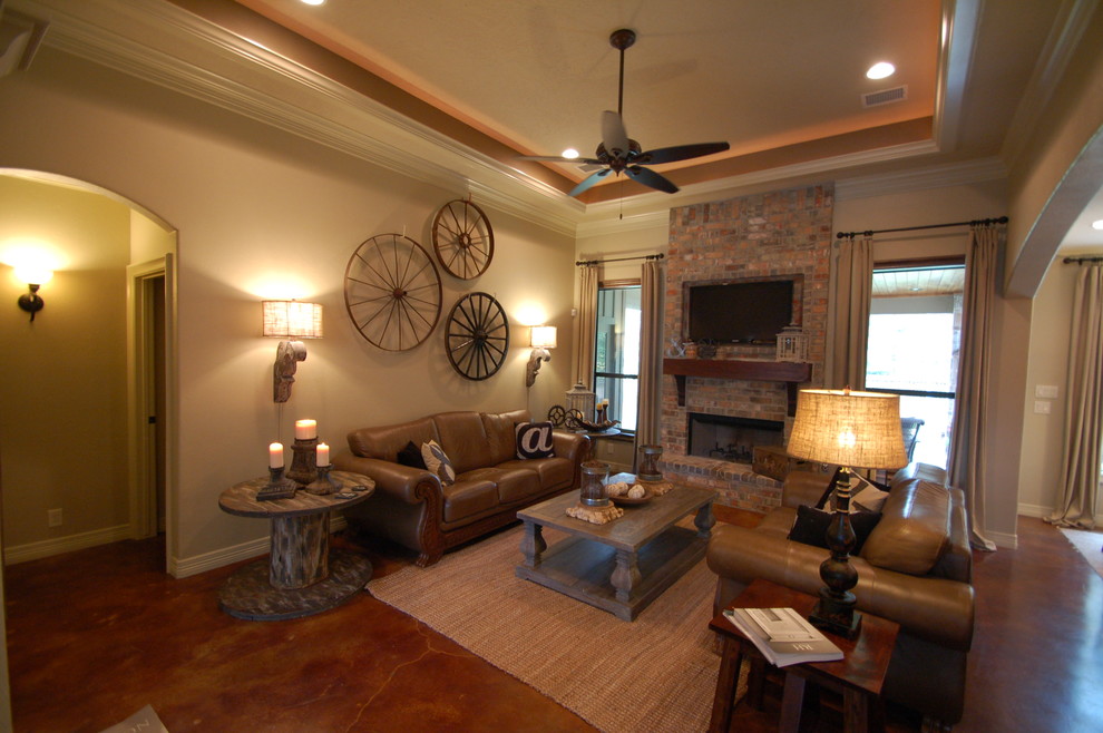 Example of a small mountain style open concept concrete floor family room design in Houston with beige walls, a standard fireplace, a brick fireplace and a wall-mounted tv