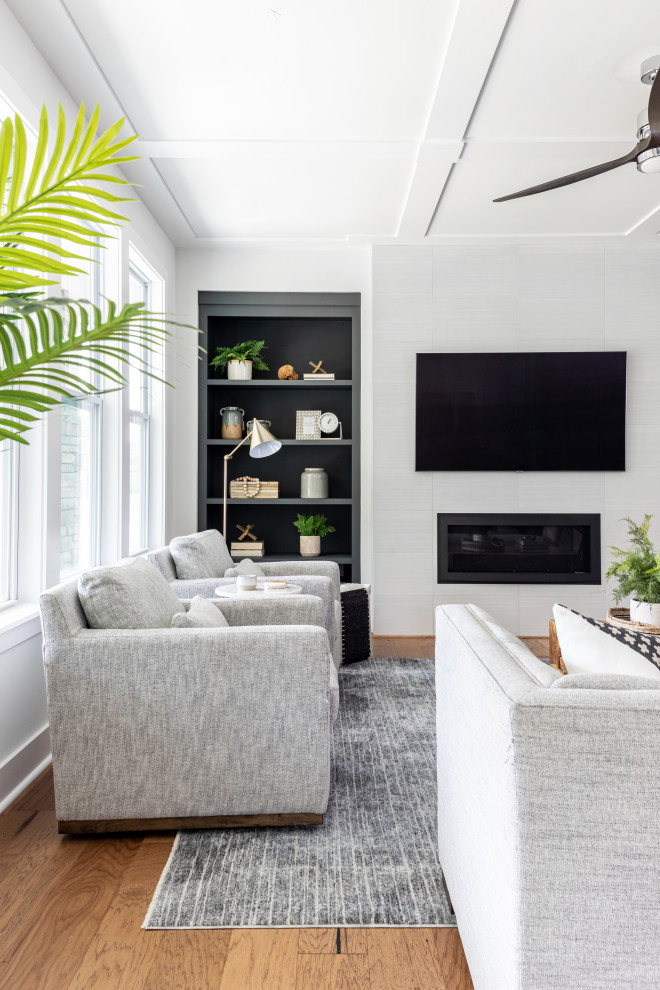 На фото: гостиная комната в стиле модернизм с белыми стенами, фасадом камина из плитки, телевизором на стене и кессонным потолком с