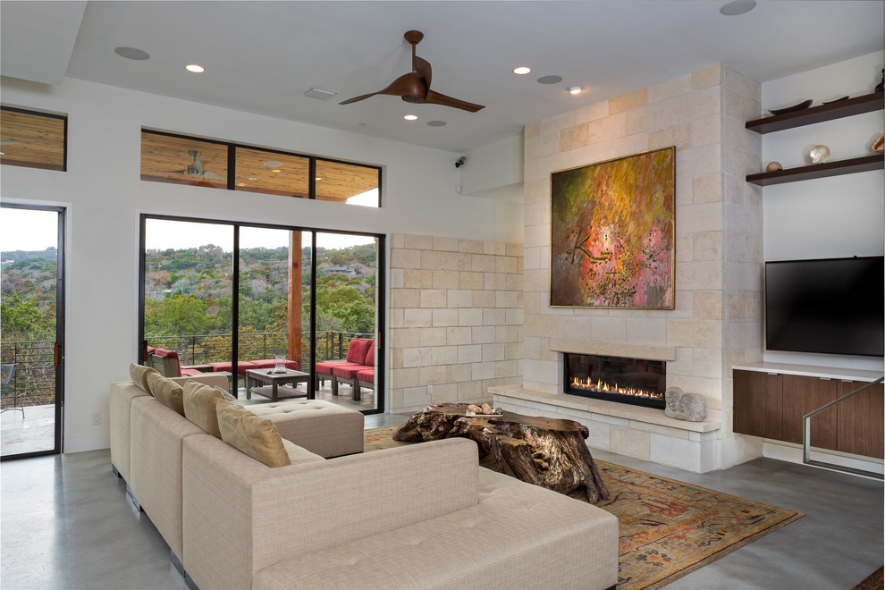 Photo of a contemporary games room in Austin with concrete flooring, a ribbon fireplace, a wall mounted tv and grey floors.