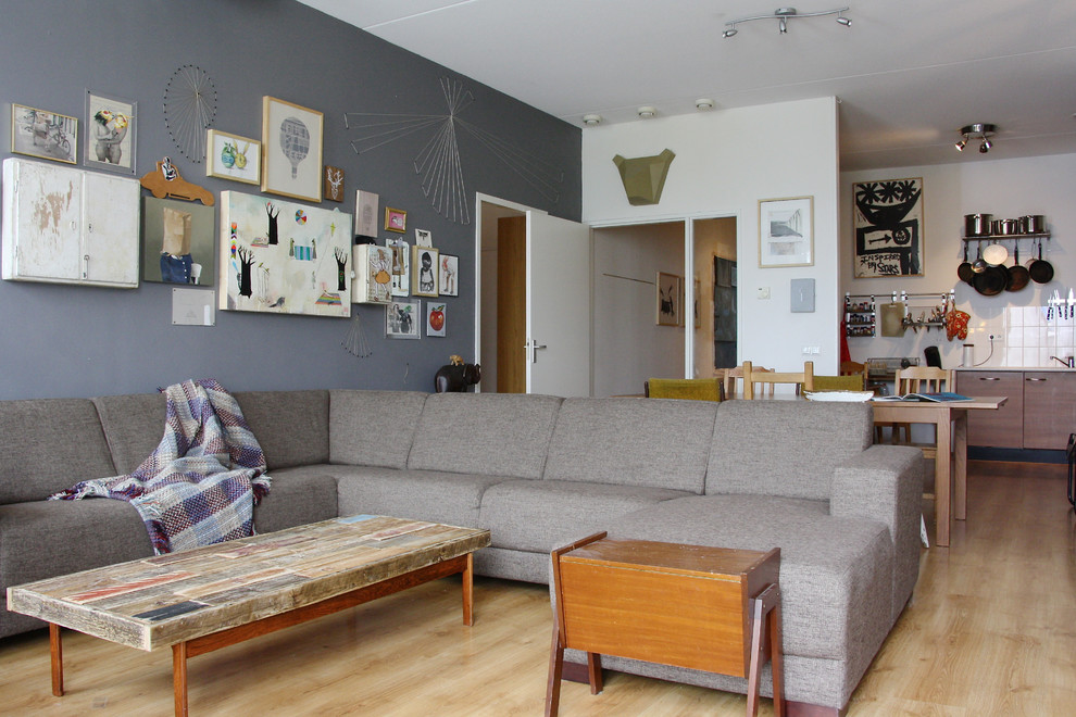 На фото: открытая гостиная комната в стиле фьюжн с серыми стенами с