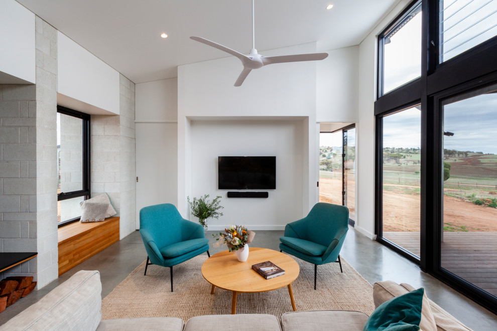 Идея дизайна: гостиная комната среднего размера в современном стиле с бетонным полом, печью-буржуйкой и серым полом