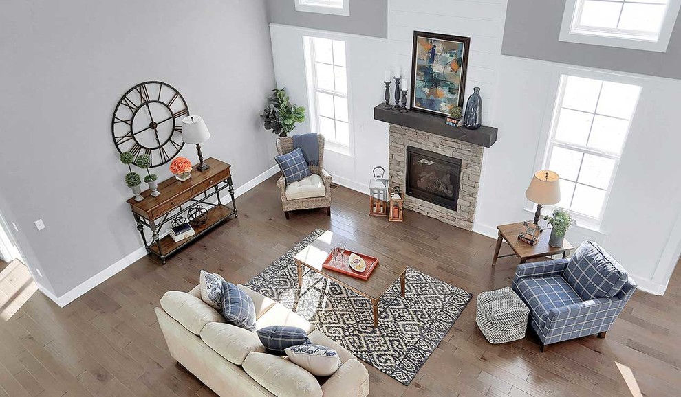 Großes, Offenes Klassisches Wohnzimmer mit grauer Wandfarbe, braunem Holzboden, Kamin und Kaminumrandung aus Stein in Sonstige