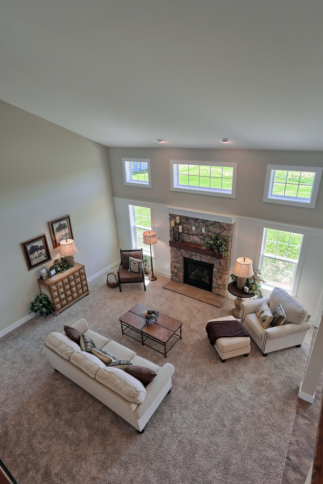 Diseño de sala de estar abierta clásica renovada grande con paredes beige, moqueta, todas las chimeneas, marco de chimenea de piedra y suelo beige