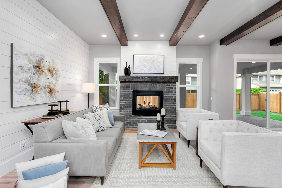 Ejemplo de sala de estar abierta de estilo de casa de campo grande con paredes grises, suelo de madera clara, suelo beige, todas las chimeneas y marco de chimenea de ladrillo