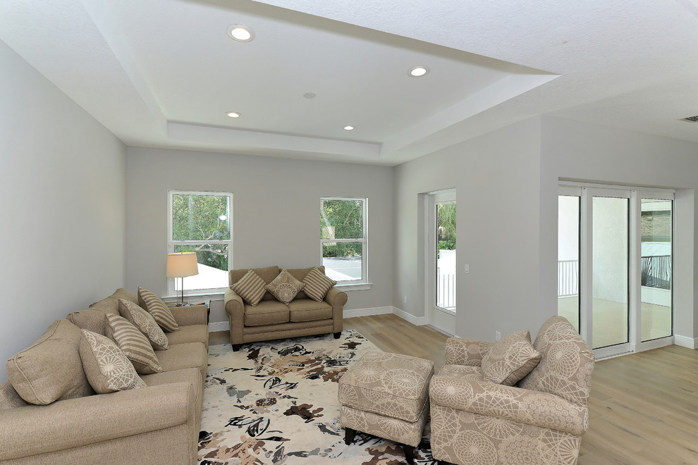 Large traditional open plan games room in Tampa with a game room, grey walls and light hardwood flooring.