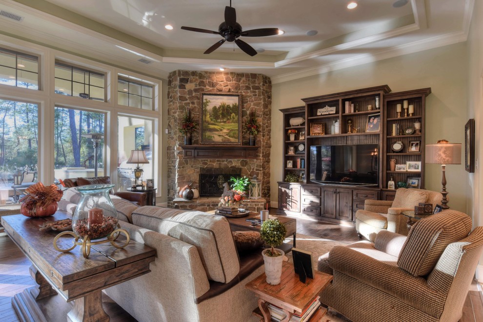 Example of a large eclectic open concept dark wood floor family room design in Houston with green walls, a corner fireplace, a stone fireplace and a media wall