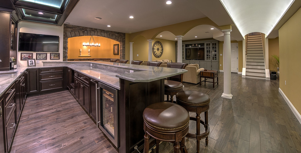 Huge elegant open concept dark wood floor and brown floor family room photo in Other with yellow walls, a bar, no fireplace and a wall-mounted tv