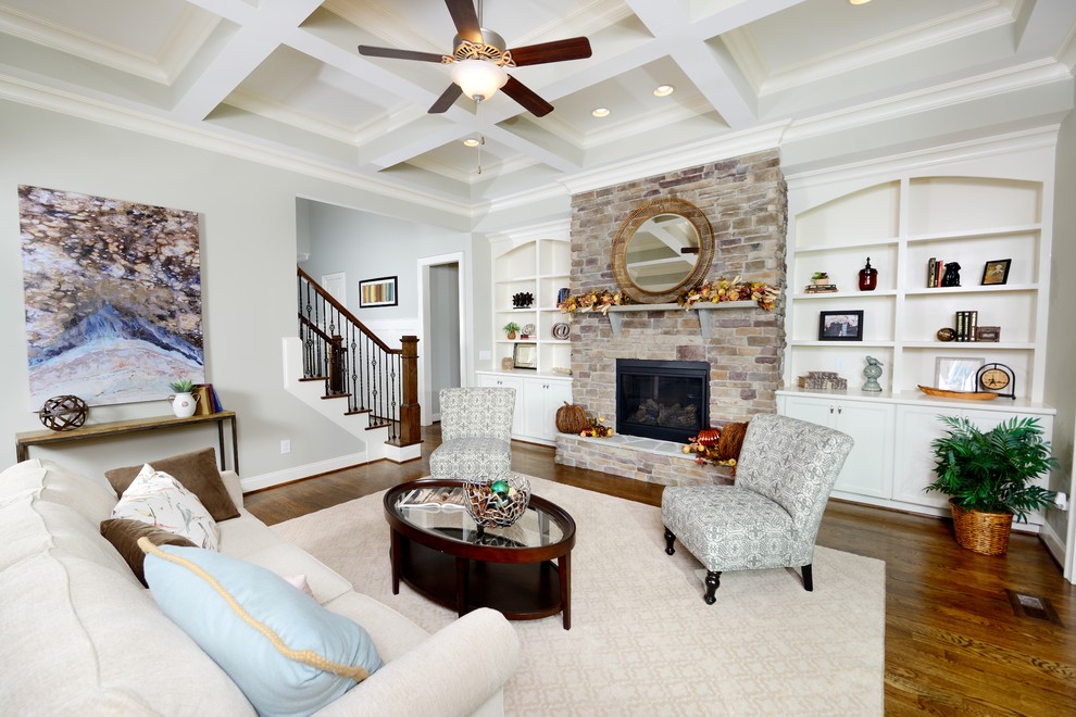 This is an example of a classic open plan games room in Raleigh with medium hardwood flooring, a standard fireplace and a stone fireplace surround.
