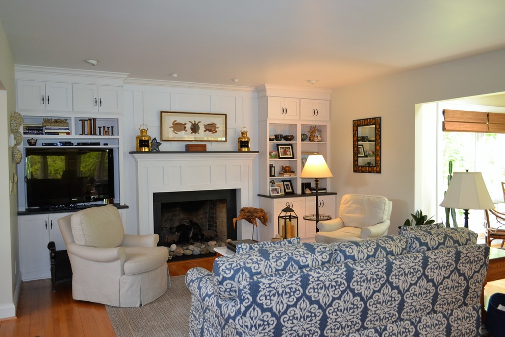 Example of a classic medium tone wood floor family room design in Richmond with a standard fireplace and a tv stand