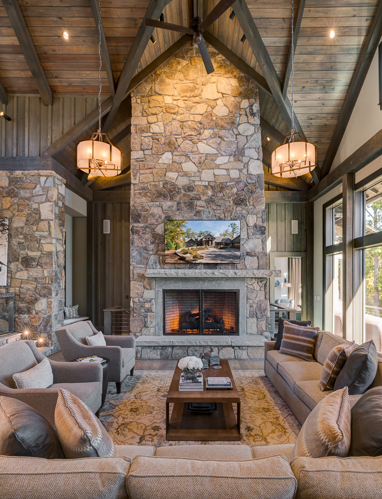 Diseño de sala de estar rural con todas las chimeneas, marco de chimenea de piedra y televisor colgado en la pared