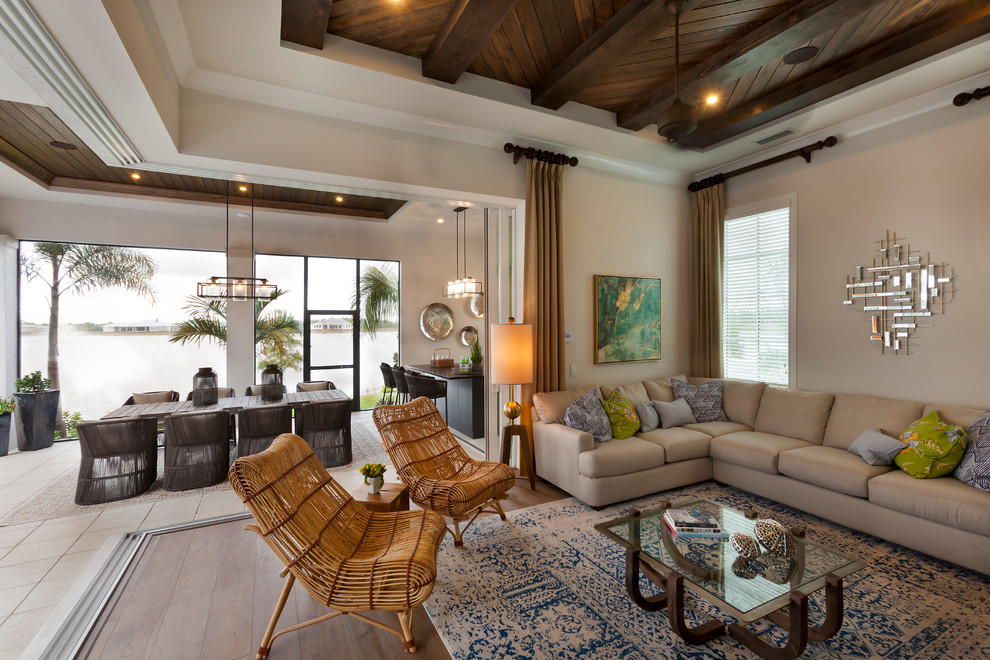 Esempio di un grande soggiorno tropicale con pareti beige, pavimento in legno massello medio e pavimento marrone