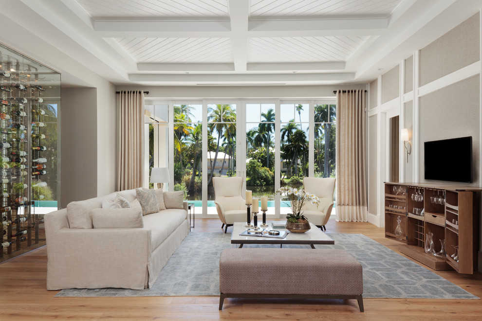 Offenes Maritimes Wohnzimmer ohne Kamin mit Hausbar, grauer Wandfarbe, hellem Holzboden und TV-Wand in Miami