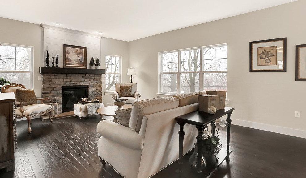 Modelo de sala de estar abierta clásica de tamaño medio con paredes beige, suelo de madera oscura y todas las chimeneas