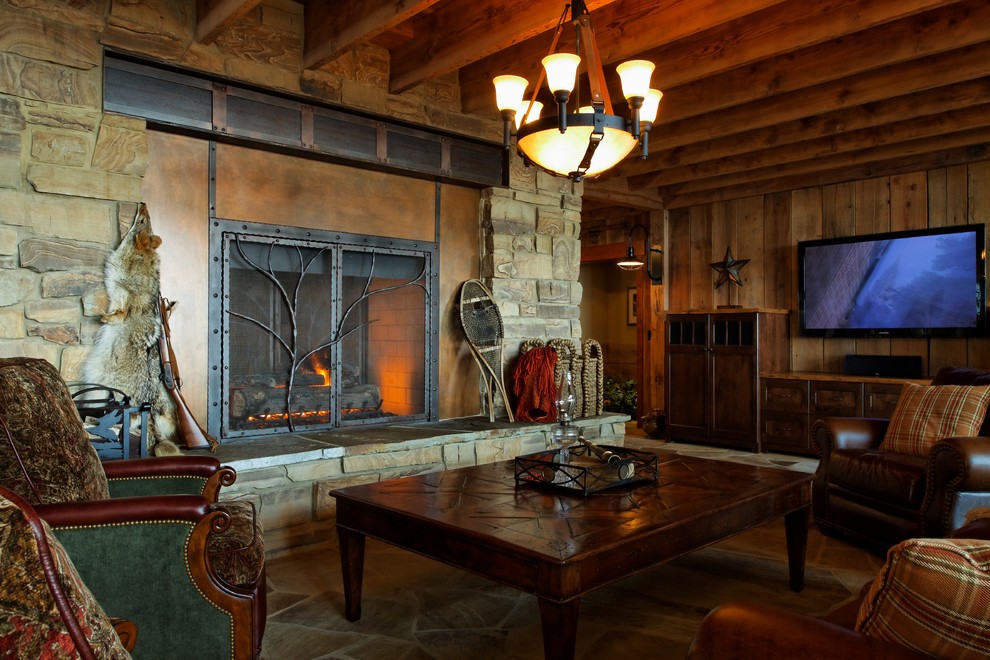 Пример оригинального дизайна: огромная гостиная комната в стиле рустика с коричневыми стенами, полом из сланца и телевизором на стене