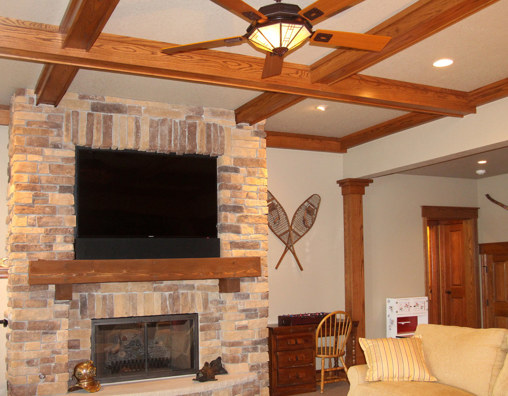 Modelo de sala de estar abierta de estilo americano grande con todas las chimeneas, marco de chimenea de piedra, televisor colgado en la pared y moqueta