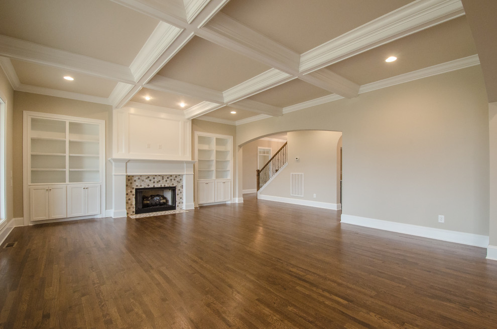 Foto de sala de estar abierta clásica grande sin televisor con paredes beige, suelo de madera en tonos medios y todas las chimeneas