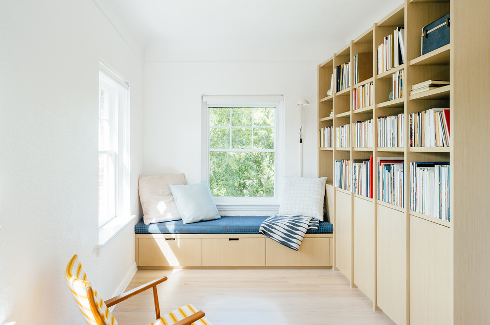 На фото: маленькая гостиная комната в скандинавском стиле с светлым паркетным полом, бежевым полом, с книжными шкафами и полками и белыми стенами без камина, телевизора для на участке и в саду с
