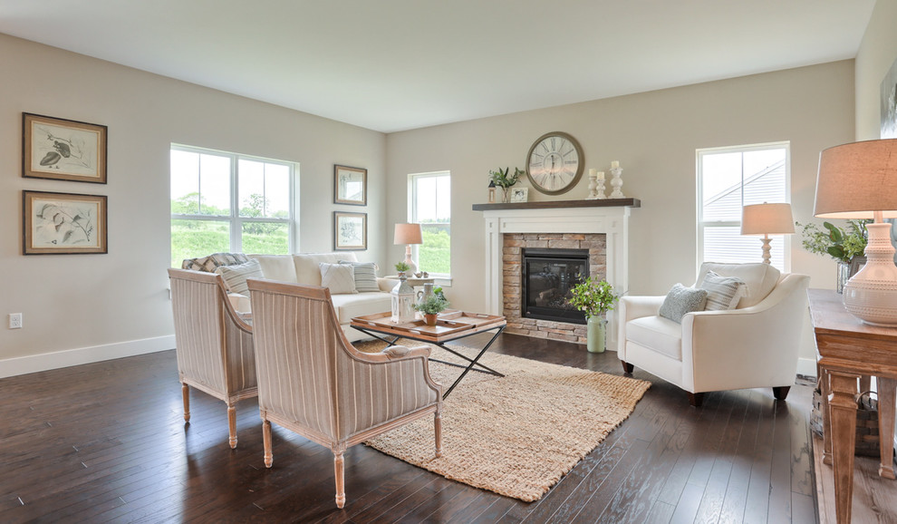 Foto de sala de estar abierta tradicional grande con paredes grises, suelo de madera en tonos medios, todas las chimeneas y marco de chimenea de piedra