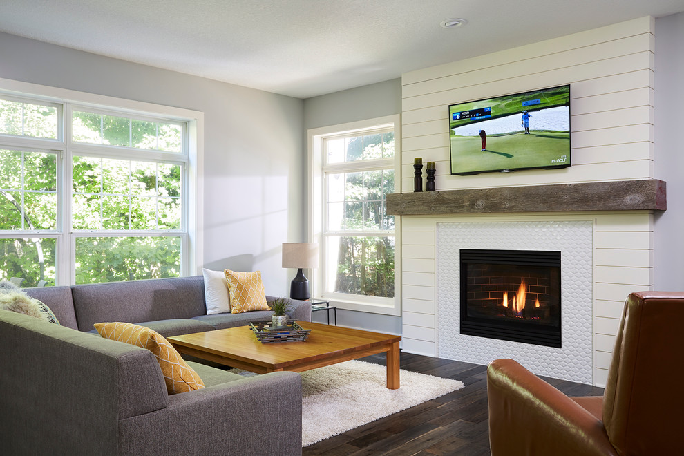 Photo of a medium sized classic open plan games room in Minneapolis with a music area, grey walls, dark hardwood flooring, a standard fireplace, a tiled fireplace surround and a wall mounted tv.