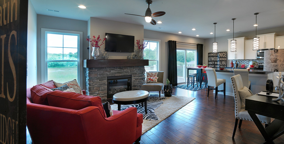 Foto de sala de estar abierta tradicional renovada de tamaño medio con paredes grises, todas las chimeneas, marco de chimenea de piedra y televisor colgado en la pared