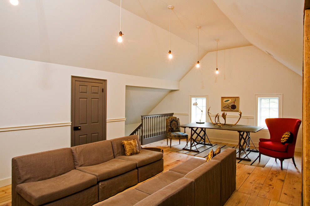 Cette image montre une salle de séjour rustique ouverte avec un mur blanc et un sol en bois brun.