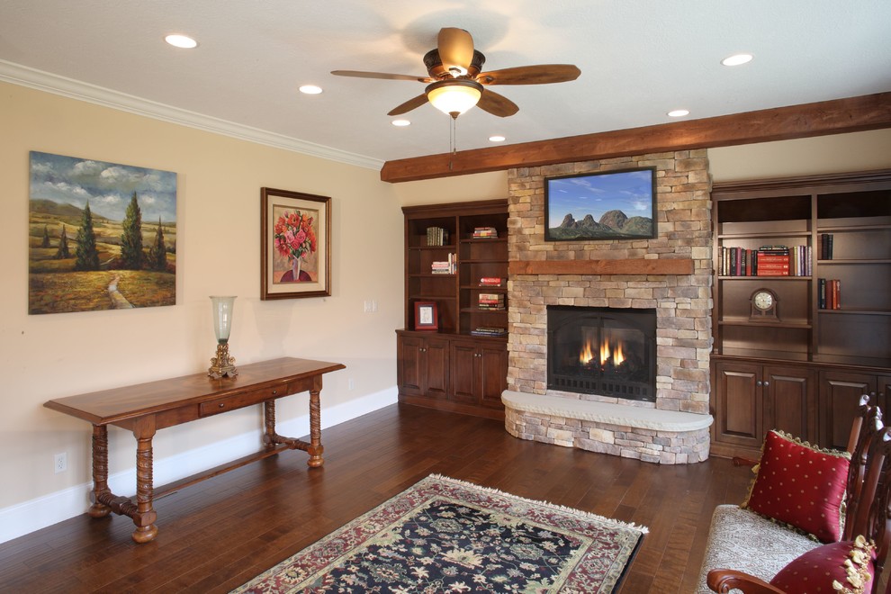 Example of a mid-sized classic open concept dark wood floor family room design in Cleveland with beige walls, a standard fireplace, a stone fireplace and a wall-mounted tv