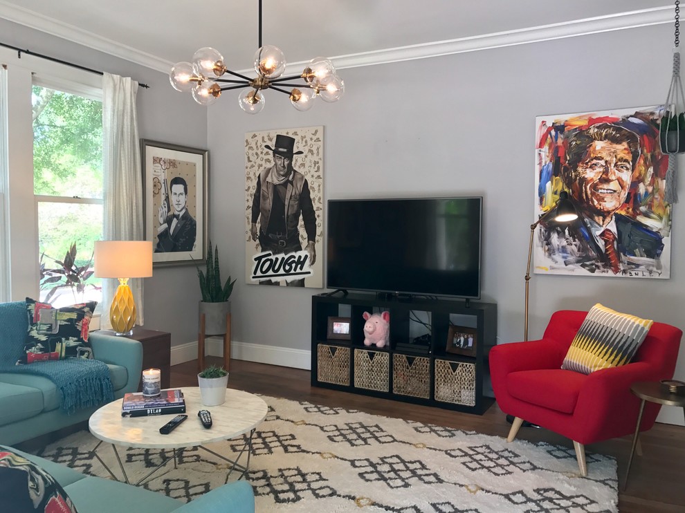 Modelo de sala de estar abierta actual de tamaño medio sin chimenea con paredes grises, suelo de madera oscura, televisor independiente y suelo marrón