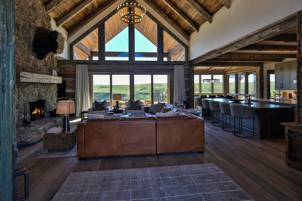 Inspiration for a large rustic open plan games room in Other with white walls, medium hardwood flooring, a standard fireplace, a stone fireplace surround and a freestanding tv.