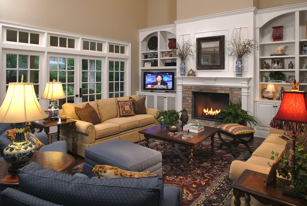 Family room - large traditional open concept dark wood floor family room idea in Other with beige walls, a standard fireplace, a brick fireplace and a tv stand