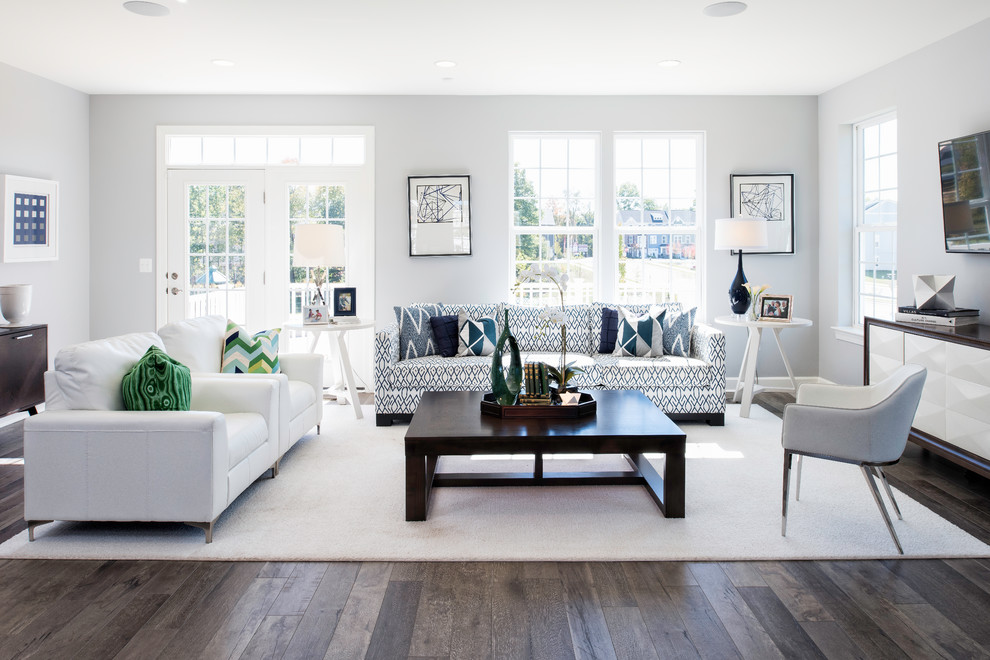 Imagen de sala de estar abierta tradicional renovada con paredes grises, suelo de madera oscura y televisor colgado en la pared