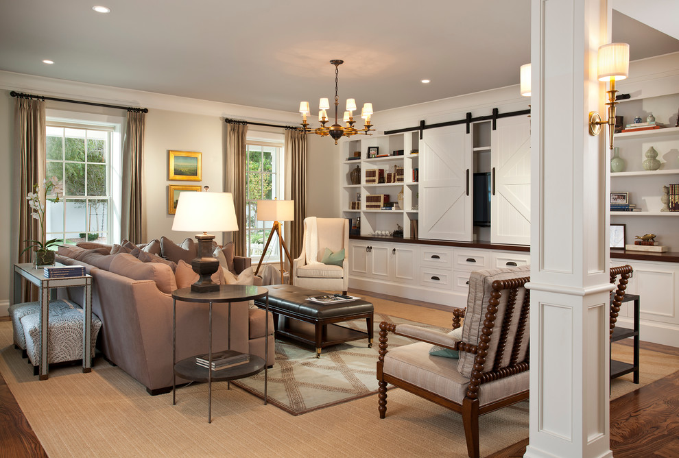 Ejemplo de sala de estar abierta tradicional renovada de tamaño medio sin chimenea con suelo de madera oscura, paredes beige, pared multimedia y suelo marrón