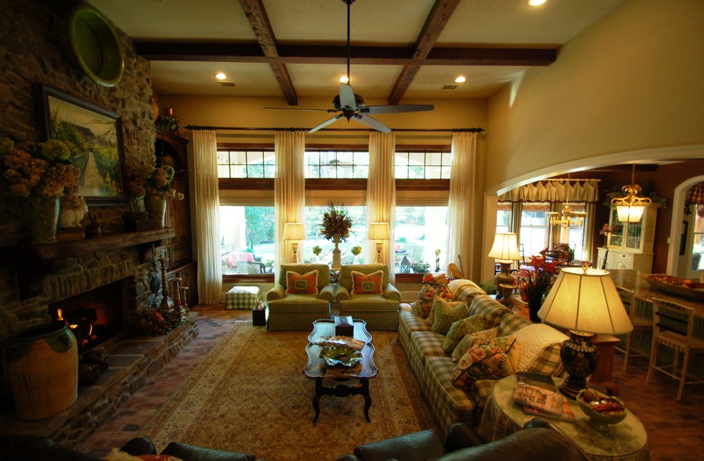 Ejemplo de sala de estar abierta bohemia con paredes beige, suelo de ladrillo, todas las chimeneas y marco de chimenea de piedra