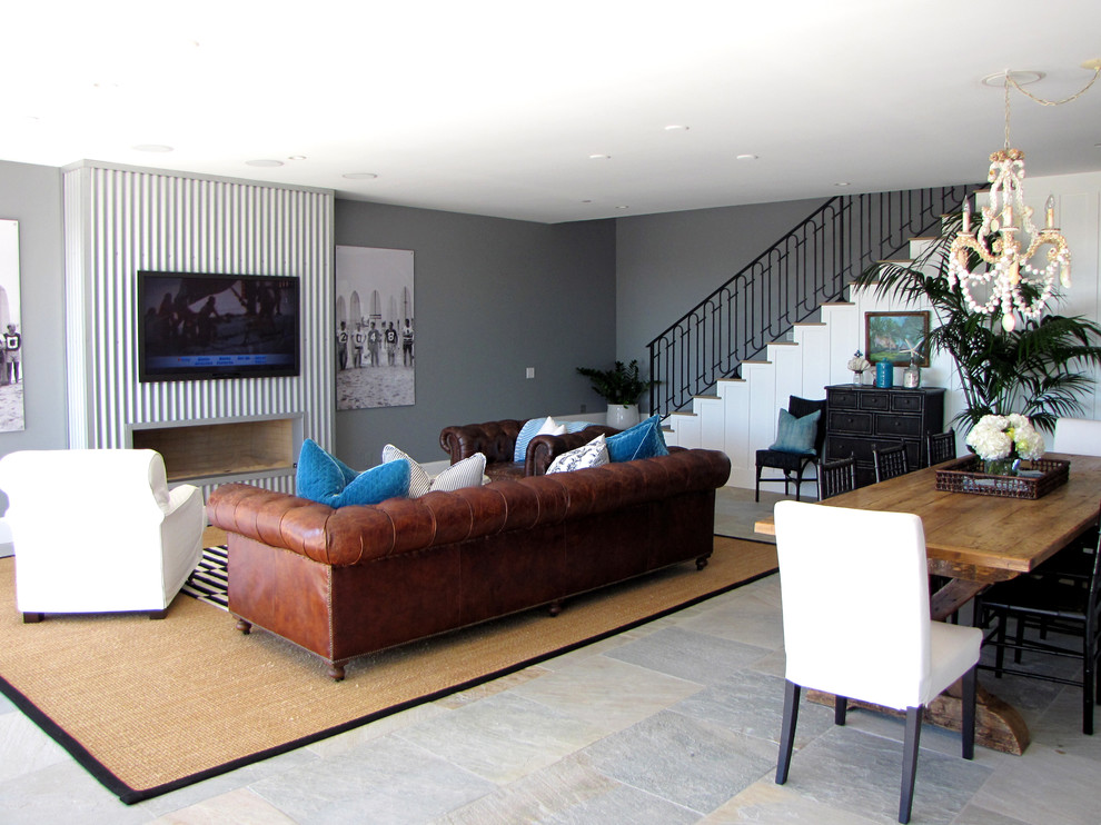 Offenes Maritimes Wohnzimmer mit grauer Wandfarbe, Gaskamin, Kaminumrandung aus Metall und TV-Wand in Orange County